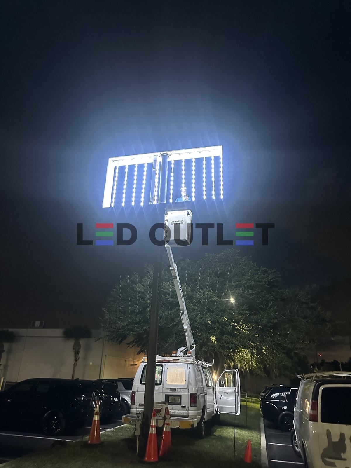 LED OUTLET bucket truck installing a parking lot pole light at night